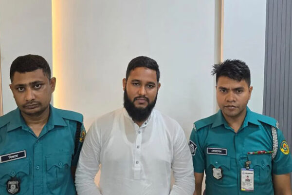 দুইজন পুলিশের মাঝখানে গ্রেপ্তার হওয়া জামায়েতে ইসলামির কর্মি সিবাগাত উল্লাহ আকাশ চৌধুরী। ফাইল ছবি।