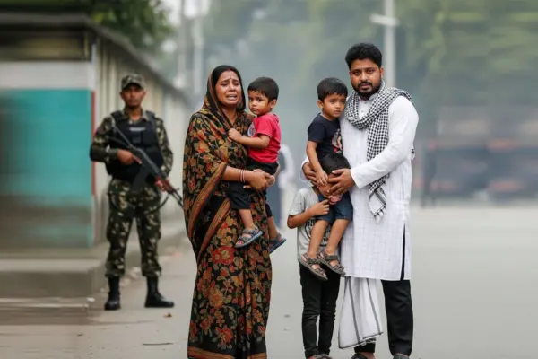 যুদ্ধের ভয়াবহতায় আতংকিত একটি পরিবার এবং পিছনে বন্দুক হাতে দাঁড়ানো একজন সৈনিক সদস্য