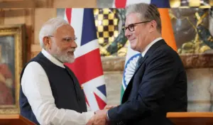 ভারতের প্রধানমন্ত্রী নরেন্দ্র মোদি এবং যুক্তরাজ্যের প্রধানমন্ত্রী কিয়ার স্টারমার চুক্তি সম্পাদন অনুষ্ঠানে আন্তরিকভাবে করমর্দন করছেন।