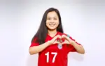 বাংলাদেশের নারী ফুটবল তারকা ঋতুপর্ণা চাকমা হাত দিয়ে হার্ট শেইপ করে বাংলাদেশের পতাকা লক্ষ করাচ্ছেন