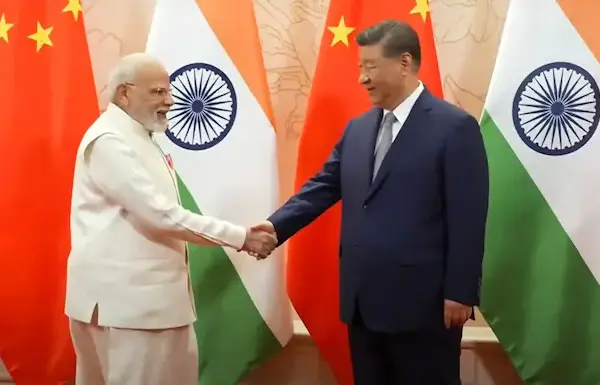 ভারত ও চীন একে অপরের প্রতিদ্বন্দ্বী নয়, বরং উন্নয়ন সহযোগী: মোদি ও শি ভারতের প্রধানমন্ত্রী নরেন্দ্র মোদি এবং চীনের প্রেসিডেন্ট শি জিনপিং হাত মেল্লাচ্ছেন এবং পিছনে দুই দেশের পতাকা দেখা যাচ্ছে।