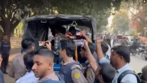 পুলিশের গাড়িতে করে নিয়ে যাওয়া হচ্ছে আটকদের।