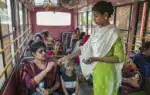 এক যাত্রীর কাছ থেকে ভাড়া নিচ্ছেন নারী কন্ডাক্টর।