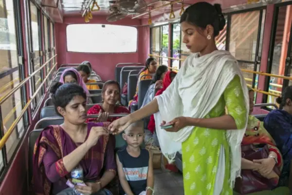 এক যাত্রীর কাছ থেকে ভাড়া নিচ্ছেন নারী কন্ডাক্টর।