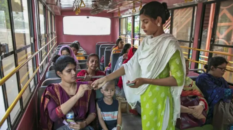 এক যাত্রীর কাছ থেকে ভাড়া নিচ্ছেন নারী কন্ডাক্টর।